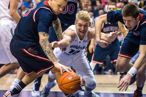 Chris Detrick  |  The Salt Lake Tribune
St. Mary's Gaels guard Kerry Carter (3) Brigham Young Cougars forward Ryan Andrus (10) and St. Mary's Gaels forward Dane Pineau (11) go for the ball during the game at the Marriott Center Thursday February 12, 2015.