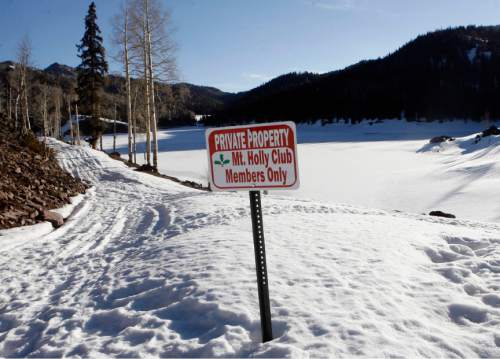 One of the questionable signs put up by the Mt. Holly Club at the access point to Puffer Lake, (behind).   About 20 feet to the right of this sign is a brown Division of Wildlife Rescources sign that states that Puffer Lake and lakes nearby are managed for recreational fishing by the Utah Division of Wildlife Rescources in cooperation with the private landowner.   This arrangement has existed for many years.  The new Mt. Holly sign discourages and confuses average folks into not walking down the access road to the lake.   Al Hartmann/Salt Lake Tribune   3/15/07