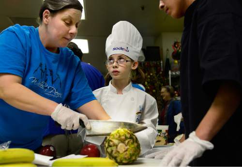 Scott Sommerdorf   |  The Salt Lake Tribune
Emma Herrera, a fourth grader from Armstrong Academy, gets instruction from Raquel Druce, kitchen manager at the Granite Education Center Cafe as she makes "Fruit Pizza"  during the Granite School District 2015 Future Chefs competition on Friday.