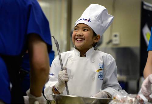Scott Sommerdorf   |  The Salt Lake Tribune
Ava Khaosanga, a 4th grader at Fox Hills Elementary  smiles as she gets support from her assistant, Raquel Druce, the kitchen manager at Granite Education Center Café as they make "Pineapple Salsa" together.
 Dozens of elementary students from schools throughout Granite School District competed as they prepared their favorite recipes in the 2015 Future Chefs competition, Friday, February 20, 2015.