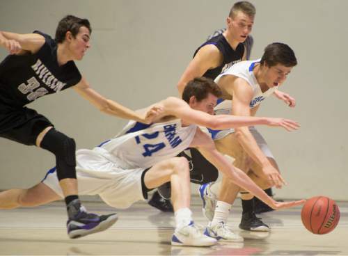 Rick Egan  |  The Salt Lake Tribune

Bingham forward Jared Holman (24) and Josh Newbold (32) go for a loose ball along with Riverton guard John Arens (30), in 5A Boys Basketball State Tournament action, Bingham vs Riverton, at the Dee Event Center, Monday, February 23, 2015