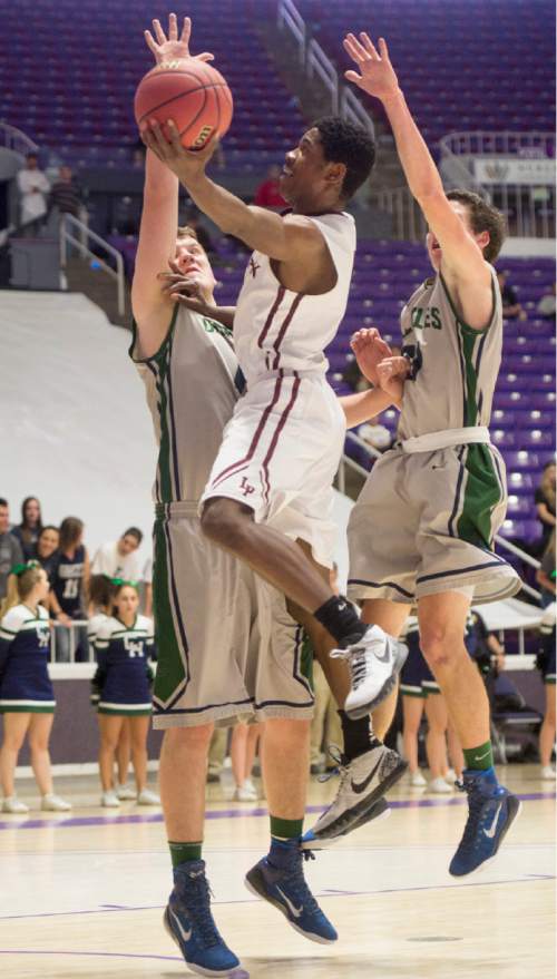 Rick Egan  |  The Salt Lake Tribune

Lone Peak guard Christian Popoola (51) gets past two Grizzlie defenders to score for the Knights,  in 5A Boys Basketball StateTournament action, Lone Peak vs Copper Hills, at the Dee Event Center, Monday, February 23, 2015