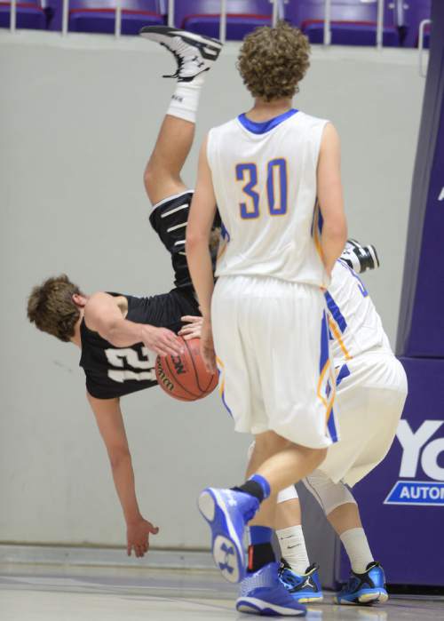 Steve Griffin  |  The Salt Lake Tribune

Highland's Spencer Divver (12) flips over Orem's Hayden Young (3) after falling for a pump fake during opening round of the boy's 4A basketball state tournament game at the Dee Event Center in Ogden, Tuesday, February 24, 2015.