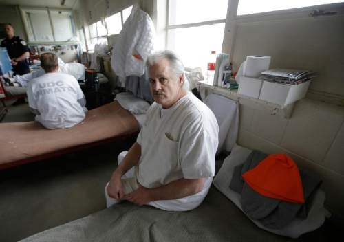 Inmate John Morrell sits on his bed in the geriatric unit during a media tour Thursday, Feb. 26, 2015, at the Utah State Correctional Facility in Draper, Utah. Gov. Gary Herbert said Thursday that he's opposed to the idea of allowing a state commission to pick a location to build a new prison instead of leaving the decision with the Legislature. (AP Photo/Rick Bowmer, Pool)