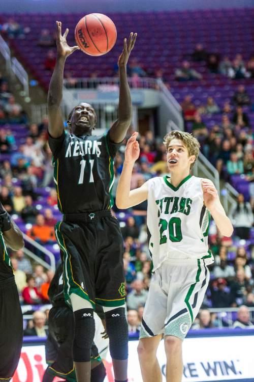 Chris Detrick  |  The Salt Lake Tribune
Kearns's Buay Kuajian (11) and Olympus's Isaac Monson (20) go for a rebound during the 4A semifinal game at the Dee Events Center Friday February 27, 2015.  Kearns defeated Olympus 63-52