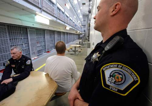 Department of Corrections Officers are shown with an inmate in Wasatch A-East block during a media tour Thursday, Feb. 26, 2015, at the Utah State Correctional Facility in Draper, Utah. Gov. Gary Herbert said Thursday that he's opposed to the idea of allowing a state commission to pick a location to build a new prison instead of leaving the decision with the Legislature. (AP Photo/Rick Bowmer, Pool)