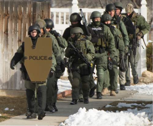 Rick Egan  |  The Salt Lake Tribune

Swat team members get into position, near 9200 South and Quail Hollow Drive in Sandy.  A 37-year-old male was found dead in the home after the 5 hour stand off,  Thursday, March 5, 2015