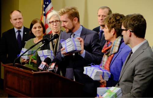 Francisco Kjolseth  |  The Salt Lake Tribune 
Executive Director of Equality Utah, Troy Williams holds some of the 8,000 cards that have been written in support of SB296, the nondiscrimination bill, as he is joined by other "Capitol 13" members, who were arrested last year in their LGBT protest, during a presser alongside House and Senate Representatives on Friday, March 6, 2015.