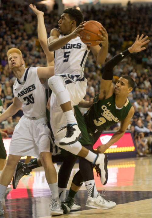 Rick Egan  |  The Salt Lake Tribune

Utah State guard Julion Pearre (5) gets past Colorado State Rams guard Gian Clavell (3) to score for the Aggies,  in basketball action, Utah State vs. Colorado State, in Logan, Saturday, March 7, 2015