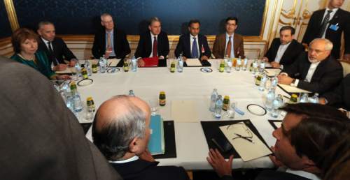 Former EU foreign policy chief Catherine Ashton, left, British Foreign Secretary Philip Hammond, rear center, Iranian Foreign Minister Mohammad Javad Zarif, right, and French Foreign Minister Laurent Fabius, front left, wait prior to closed-door nuclear talks with Iran in Vienna, Austria, Friday, Nov. 21, 2014. (AP Photo/Ronald Zak)