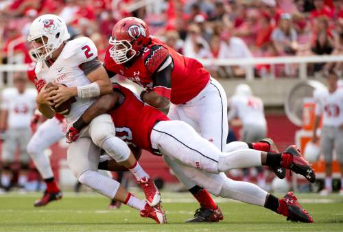 Jeremy Harmon  |  The Salt Lake Tribune

Fresno State's Brian Burrell (2) gets sacked by Utah's Pita Taumoepenu (50) and Wallace Gonzalez (32) as the Utes host the Bulldogs at Rice-Eccles Stadium on Saturday, Sept. 6, 2014.