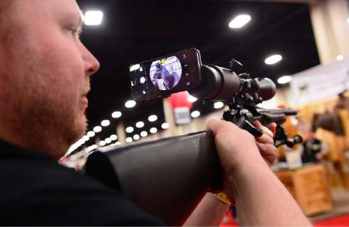 Scott Sommerdorf   |  The Salt Lake Tribune
Chad Schuessler of iSCOPE demonstrates the iSCOPE smartphone scope adapter that allows hunters to document their hunting experience with their own phones. Seen at the iSCOPE booth at the International Sportsmen's Expo at the South Towne Expo Center, Thursday, March 12, 2015. The show continues through Sunday.