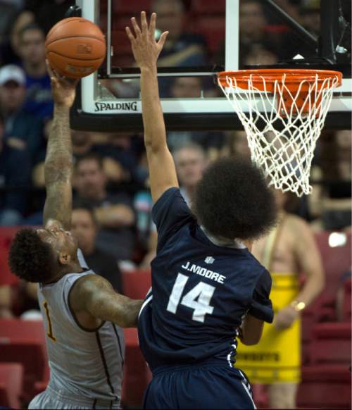 Rick Egan  |  The Salt Lake Tribune

Utah State Aggies guard Jalen Moore (14) defends as Wyoming Cowboys guard Charles Hankerson Jr. (1) takes the ball to the hoop in Mountain West Conference Basketball Championship action, Utah State vs. Wyoming, at the Thomas & Mack Center in Las Vegas, Thursday, March 12, 2015.
