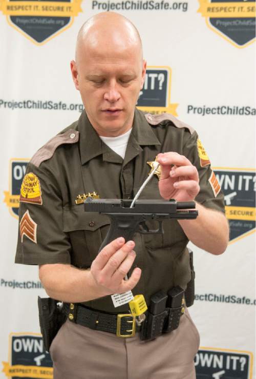 Rick Egan  |  The Salt Lake Tribune

Utah Highway patrolman Todd Royce demonstrates a cable-style gun lock at a press conference at the Department of Public Safety, Thursday, March 19, 2015.