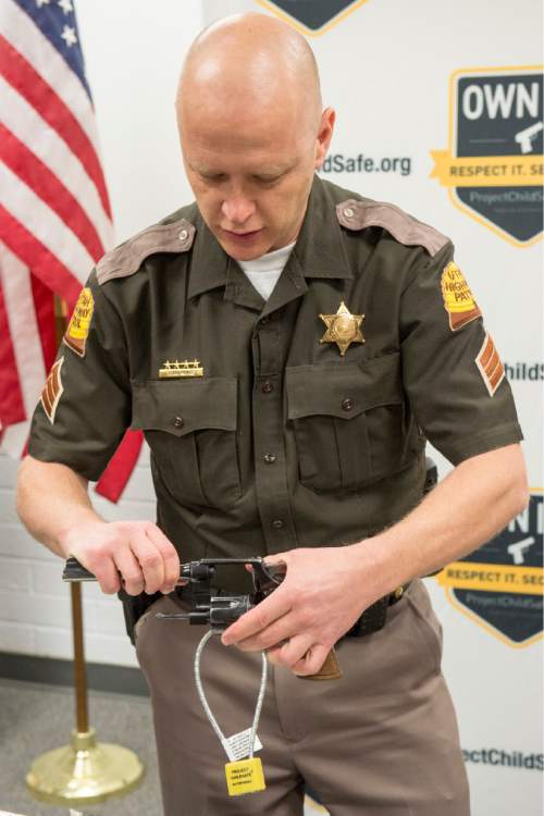 Rick Egan  |  The Salt Lake Tribune

Utah Highway patrolman Todd Royce demonstrates a cable-style gun lock at a press conference at the Department of Public Safety, Thursday, March 19, 2015.