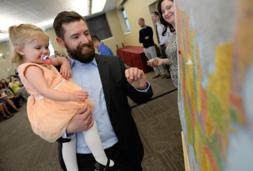 Francisco Kjolseth  |  The Salt Lake Tribune 
Daryl McLaren is joined by his daughter Phoebe, 2, as he looks to pin the map where he will complete his residency in emergency medicine at Allegheny General Hospital PA during Match Day festivities at the University of Utah.