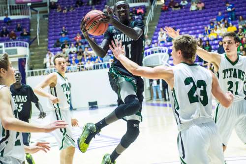 Chris Detrick  |  The Salt Lake Tribune
Kearns's Buay Kuajian (11) shoots past Olympus's Miles Keller (23) and Olympus's Jake Lindsey (21) during the 4A semifinal game at the Dee Events Center Friday February 27, 2015.