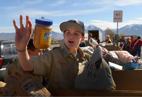 Leah Hogsten  |  The Salt Lake Tribune
Rhyn Ling of Troop 1975catches a jar of peanut butter flung by a fellow Scout at the Elkridge Elementary collection point. Utah Boy Scouts of America collected food donations during the 29th Annual Scouting for Food drive to benefit the Utah Food Bank, regional food banks and emergency food pantries across the state, Saturday, March 21, 2015. Last year's drive collected more than 1.3 million meals for Utahns in need.