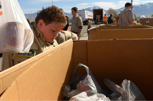 Leah Hogsten  |  The Salt Lake Tribune
Zach Thompson with Troop 1250 places a bag of food into the collection boxes at Elkridge Elementary collection point. Utah Boy  Scouts of America collected food donations during the 29th Annual Scouting for Food drive to benefit the Utah Food Bank, regional food banks and emergency food pantries across the state, Saturday, March 21, 2015. Last year's drive collected more than 1.3 million meals for Utahns in need.