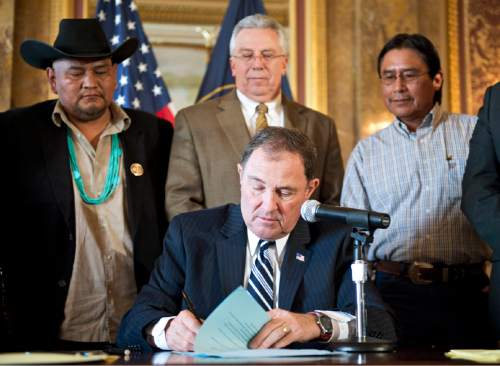 Lennie Mahler  |  The Salt Lake Tribune

Gov. Gary Herbert signs HB33, American Indian-Alaskan Education bill, in the Gold Room at the Utah State Capitol on Monday, March 30, 2015. Behind him are Davis Filfred, Navajo Nation Council delegate from Utah, Rep. Jack Draxler, chief sponsor of the bill and Navajo community member Harrison Johnson.