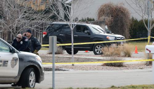 Francisco Kjolseth  |  The Salt Lake Tribune
A black SUV, still with the unseen body of a suspect shot and killed in the front seat by a West Valley police officer attempting a possible narcotics arrest sits in the Cranberry Hill neighborhood in Draper on Wednesday morning, Jan. 14, 2015. A West Valley police officer on his way to work who asked for back up from Draper police shot and killed the suspect when he brandished a knife during the struggle to arrest him.