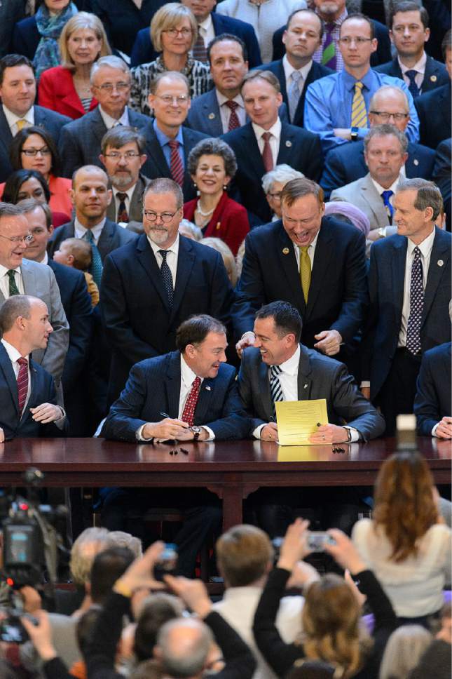 Trent Nelson  |  The Salt Lake Tribune
Gov. Gary Herbert and House Speaker Greg Hughes share a laugh while signing into law SB296, which gives statewide non-discrimination protections to the gay and transgender community, while providing safeguards for religious liberty, in the rotunda of the State Capitol Building in Salt Lake City, Thursday March 12, 2015. At rear are Senators Stephen Urquhart and Jim Dabakis, among others.