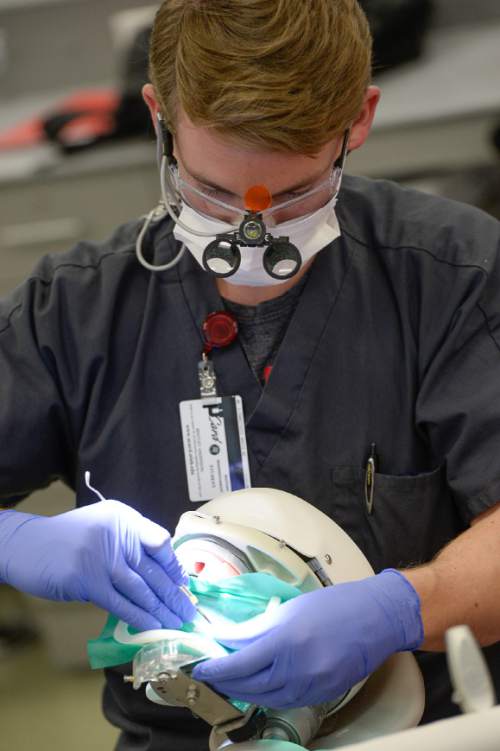 Francisco Kjolseth  |  The Salt Lake Tribune 
Bentley Anderson, a second-year dental student, practices a root canal procedure in the simulation lab at the University of Utah's new School of Dentistry. The school accepted its first four-year class of 20 students beginning in 2013 but they have had to share classroom space with others in medicine, nursing and pharmacy while the dentistry building was under construction. On Wednesday, April 8, 2015, the new $36 million building, largely funded by Utah philanthropists the late Ray and Tye Noorda, was dedicated and will be called the Ray and Tye Noorda Oral Health Sciences Building.