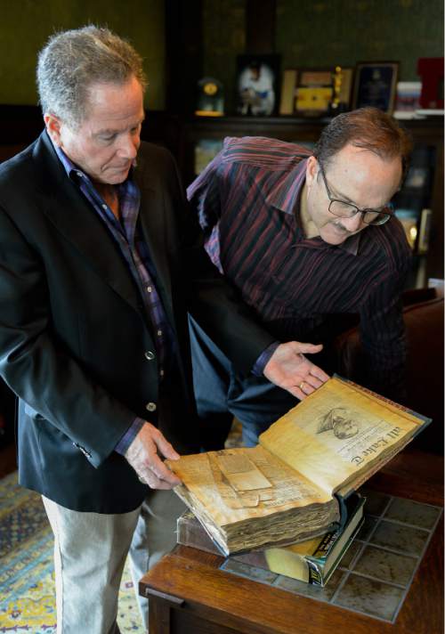 Francisco Kjolseth  |  The Salt Lake Tribune
Brothers Phil and Tom McCarthey, from left, look over a family scrapbook with old articles. The two brothers are hosting a journalism event with Bob Costas.