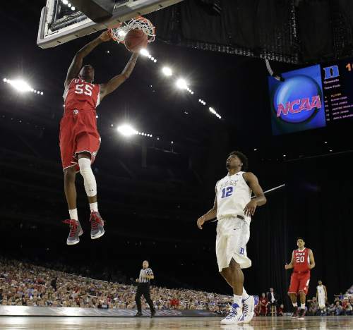 Utah's Delon Wright dunks as Duke's Justise Winslow looks on during the first half of a college basketball regional semifinal game in the NCAA Tournament Friday, March 27, 2015, in Houston. (AP Photo/Charlie Riedel)