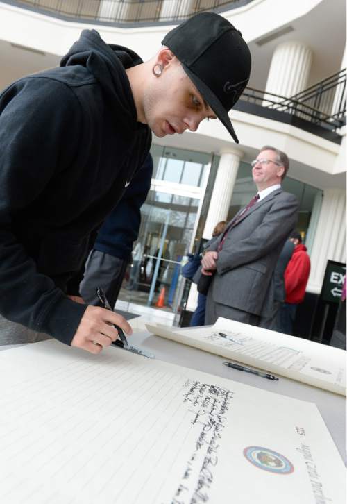 Francisco Kjolseth  |  The Salt Lake Tribune 
Psychology student Jack Tuttle adds his name to the Magna Carta Parchment as the Utah State Courts holds a ceremony at the Matheson Courthouse to recognize the 800-year anniversary of the signing of the Magna Carta. A traveling exhibit of the Magna Carta, organized by the Utah State Bar, will be on display through Friday in the Matheson Courthouse rotunda.