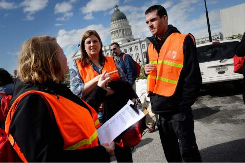 Scott Sommerdorf   |  The Salt Lake Tribune
Angela Kula, left, Wendy Miranda, and Will Clark, right, huddle as they act as group leaders to check that all their people are safe and accounted for during the annual Great Utah ShakeOut earthquake drill at the Utah State Capitol complex, Thursday, April 16, 2015.
