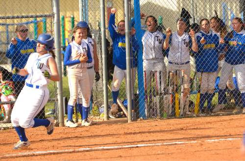 Leah Hogsten  |  The Salt Lake Tribune
Taylorsville's dugout cheers on MacKenzy Richins as she slides safe into home with the game winning run. Taylorsville High School girls softball team defeated Hunter High School 7-6 during their game in Taylorsville, Friday, April 17, 2015.
