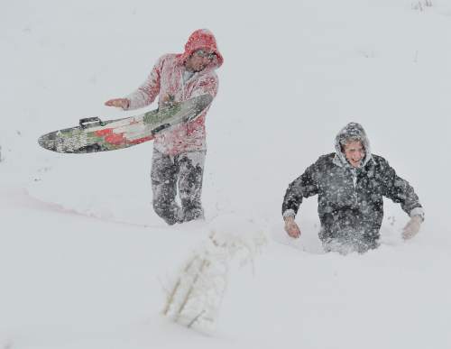 Francisco Kjolseth  |  The Salt Lake Tribune 
University of Utah students Brendan Gibson, left, and Aaron Atnip take advantage of the snow on the hills above the U. to do a little sledding before class. A powerful storm blanketed the valley in snow, covering any signs of early spring on Wednesday, April 15, 2015.