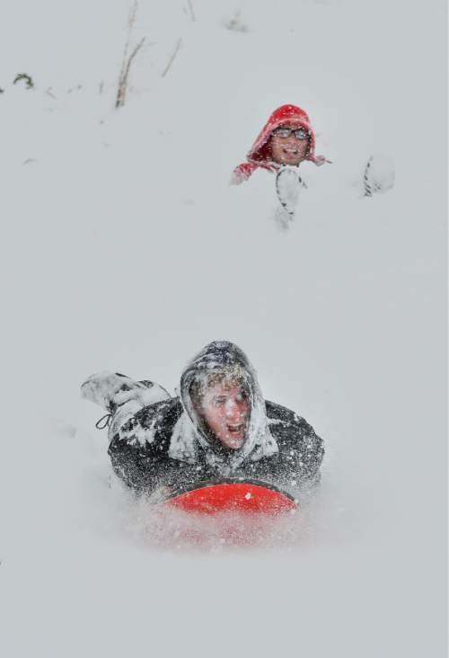 Francisco Kjolseth  |  The Salt Lake Tribune 
University of Utah student Aaron Atnip, bottom, gets a face full of snow and Brendan Gibson gets dug in as they take advantage of the snow on the hills above the U. to do a little sledding before class. A powerful storm blanketed the valley in snow, covering any signs of early spring on Wednesday, April 15, 2015.