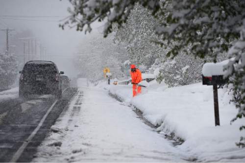 Scott Sommerdorf   |  The Salt Lake Tribune
John Kingston clears his driveway in a bright orange suit in Holladay after a spring snowfall in Salt Lake City, Wednesday, April 15, 2015.