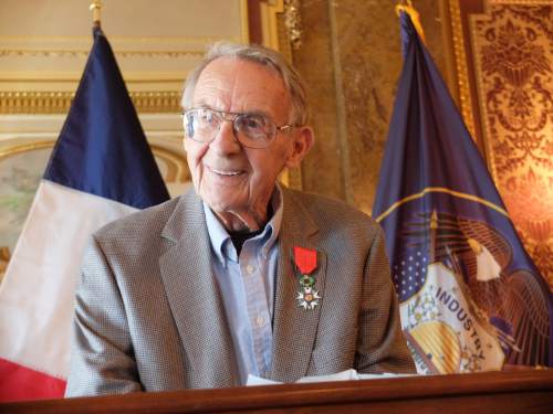 With the flags of France and Utah behind him, Sam Boyack smiles moments after receiving the French Legion of Honor on April 18, 2015, in a ceremony at the state Capitol. Boyack, 91, of Sandy, was in the U.S. Army Air Corps during World War II and participated in the liberation of France. Photo by Nate Carlisle/The Salt Lake Tribune