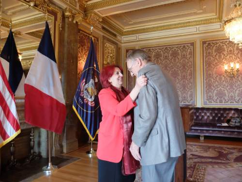 The Honorary Consul of France, Marie-Helene Glon, embraces Sam Boyack after she pins the French Legion of Honor on Boyack on April 18, 2015, in a ceremony at the state Capitol. Boyack, 91, of Sandy, was in the U.S. Army Air Corps during World War II and participated in the liberation of France. Photo by Nate Carlisle/The Salt Lake Tribune