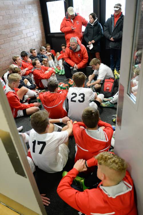 Francisco Kjolseth  |  The Salt Lake Tribune
Veteran Alta girls and boys soccer coach Lee Mitchell, kneeling, encourages his team to keep playing strong as they warm up in a hall of the school during the half time break while playing Bingham.