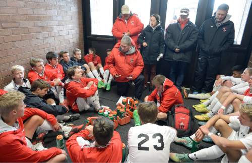 Francisco Kjolseth  |  The Salt Lake Tribune
Veteran Alta girls and boys soccer coach Lee Mitchell, kneeling, encourages his team to keep playing strong as they warm up in a hall of the school during the half time break while playing Bingham.