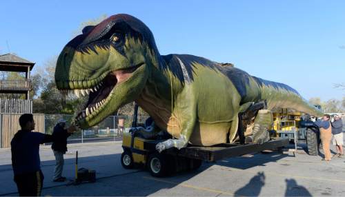 Al Hartmann  |  The Salt Lake Tribune 
Hogle Zoo staff carefully ease a Tyrannosaurus Rex from a semi trailer in the parking lot Monday April 20, 2015. Fourteen life-size "animatronic" dinosaurs arrived and will be set up throughout the zoo and displayed starting May 1 in the Zoorassic Park 2 exhibit.