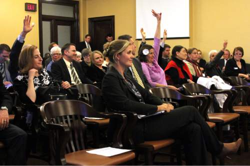 Francisco Kjolseth  |  The Salt Lake Tribune
Amanda Smith, center, Executive Director of the Utah Department of Environmental Quality is surrounded by raised hands hoping to speak in opposition to SB 21, creating revisions to the department of environmental quality boards on Wednesday, February 8, 2012.