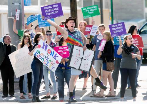 Steve Griffin  |  The Salt Lake Tribune

John Wilkes, of Murray, Utah, center, participates in a honk and wave to support same-sex marriage arguments at the U.S. Supreme Court, outside Piper Down Pub near 1500 south and State Street in Salt Lake City, Tuesday, April 28, 2015.