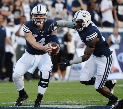 Steve Griffin  |  The Salt Lake Tribune


BYU Cougars quarterback Taysom Hill (4) fakes a handoff to BYU Cougars running back Jamaal Williams (21) during game between BYU and Houston and LaVell Edwards Stadium in Provo, Thursday, September 11, 2014.