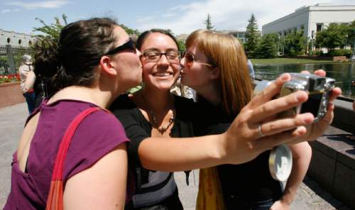 KISS-IN 2
Nicle Paul (center) documents her kisses from her friends Rachel Coffey (left) and Nicole Schlotterback (right) while in Temple Square. In solidarity with Derek Jones and Matthew Aune, arrested and handcuffed July 8 for a display of public affection on Main Street Plaza, protesters have organized a second "kiss-in" follow-up to the original July 12 "kiss-in." The July 12 protest drew 100 people. This follow-up may attract more, Sunday, 7/19/09.
Scott Sommerdorf  / The Salt Lake Tribune