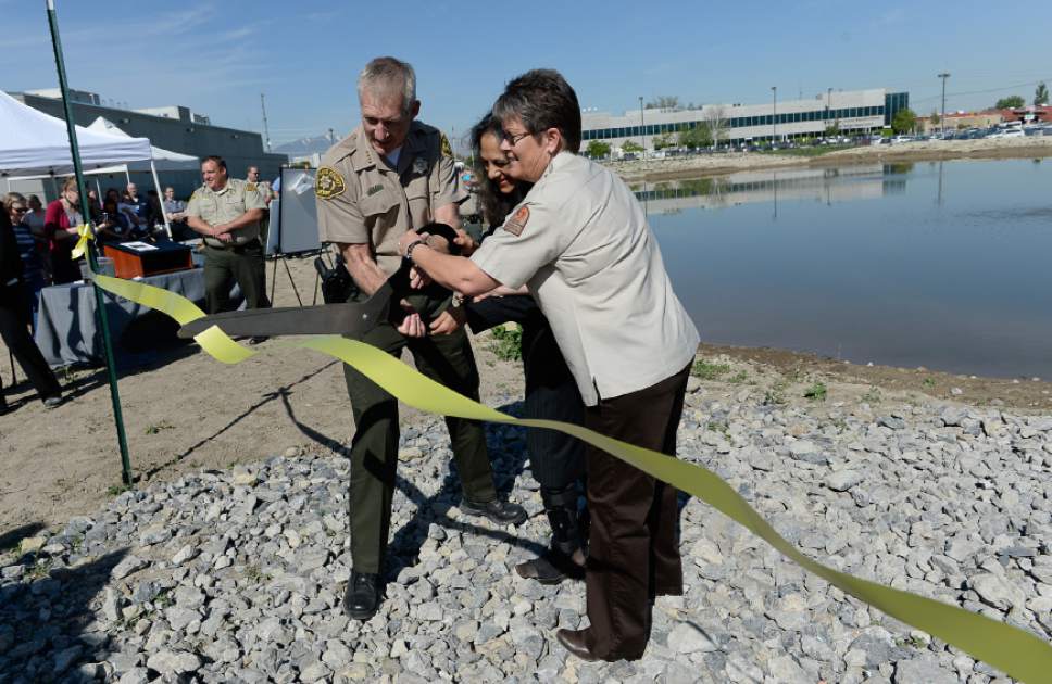 Francisco Kjolseth  |  The Salt Lake Tribune 
Salt Lake County Sheriff James M. Winder, left, Dr. Nalini Nadkarni and Krissy Wilson with the Utah Division of Wildlife Resources cut the ribbon on the new jail pond where 5,000 native Utah "Least Chub" will be planted.