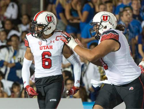Rick Egan  |  The Salt Lake Tribune

Utah Utes offensive lineman Siaosi Aiono (60) congratulates Utah Ute's wide receiver Dres Anderson (6) after his touchdown, giving the Ute's a two touchdown lead over UCLA, at the Rose Bowl in Pasadena, Saturday, October 4, 2014