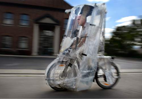 Scott Sommerdorf   |  The Salt Lake Tribune
Bill Lee rides ready for any weather inside his home-made adaptation of a Chinese electric bike that he equipped with rain cover, headlight, rear-facing camera, speedometer and windshield wipers, Sunday, May 10, 2015.