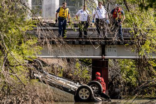 Trent Nelson  |  The Salt Lake Tribune
Law enforcement and rescue crews examine a car found overturned in the Jordan River south of the Fairgrounds, Sunday May 10, 2015.