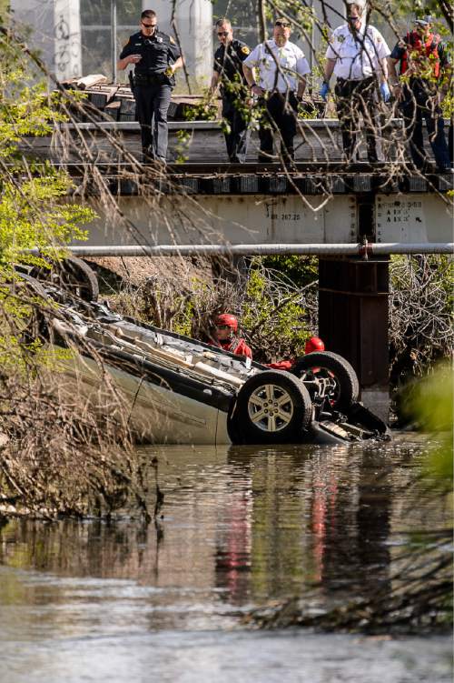Trent Nelson  |  The Salt Lake Tribune
Law enforcement and rescue crews examine a car found overturned in the Jordan River south of the Fairgrounds, Sunday May 10, 2015.