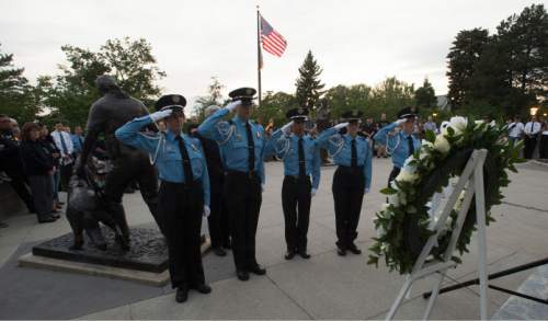 Steve Griffin  |  The Salt Lake Tribune
Members of the Salt Lake City Police Department Explorers salute after placing a wreath during a candlelight vigil hosted by the Utah Fraternal Order of Police, along with the Utah Fraternal Order of Police Auxiliary, to show appreciation to police officers who died in the line of duty at the The Utah Law Enforcement Memorial on the Utah State Capitol grounds in Salt Lake City on Wednesday.